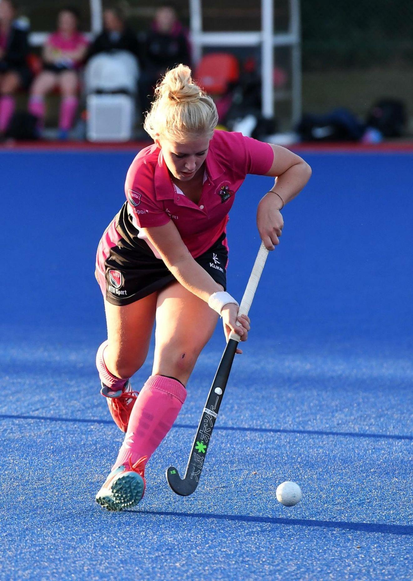 Bella Fisken driving the ball forward in a pink NTU kit