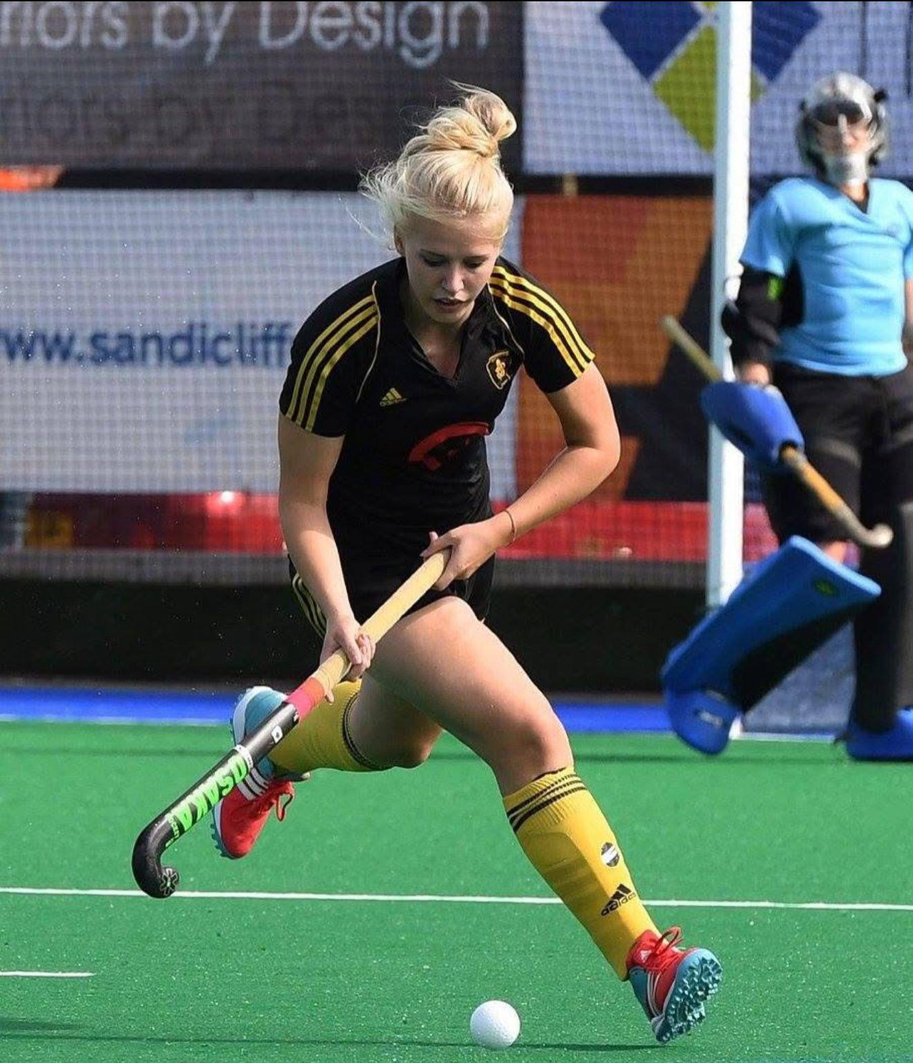 Bella Fisken dribbling past the goal in a black and yellow kit